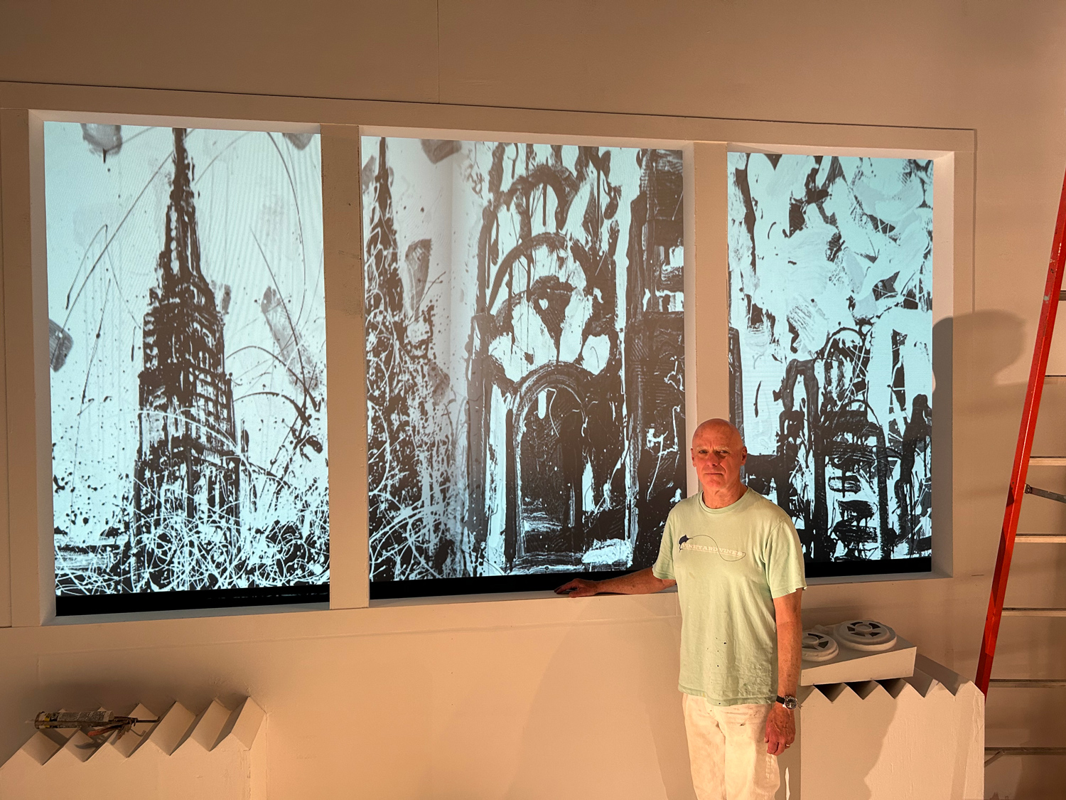 Tom in front of stage backdrop paintings